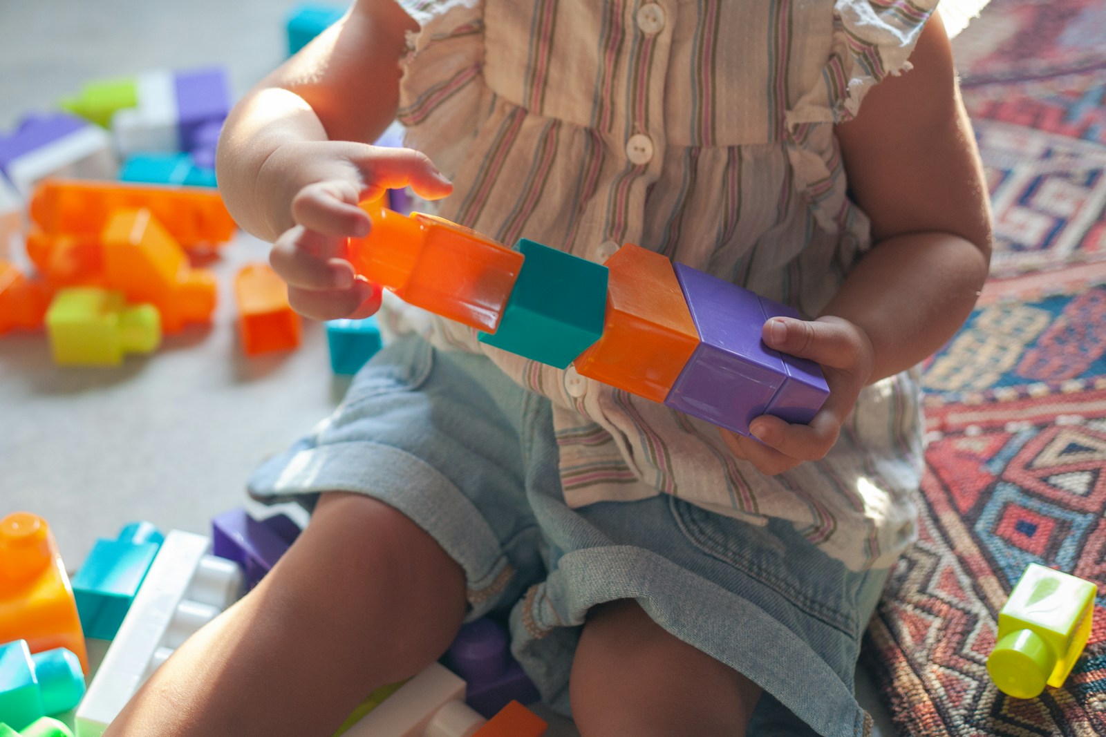 A young child holding blocks