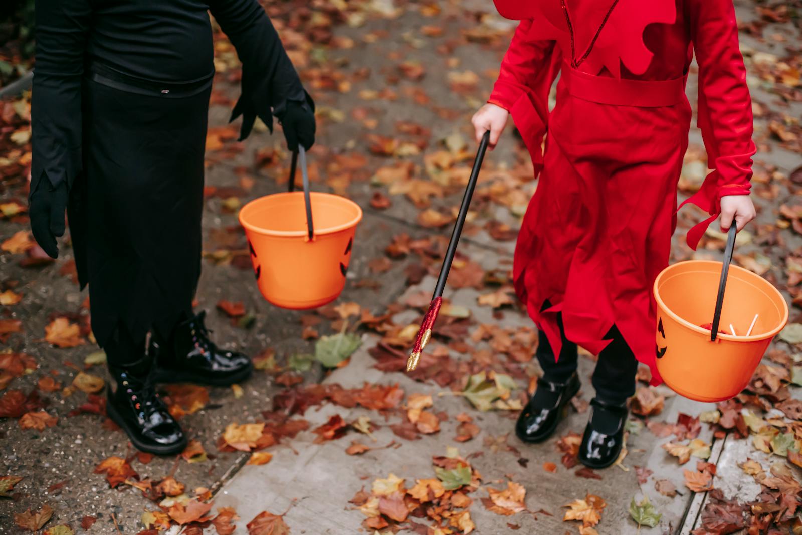 Children walking down the street with trick-or-treating buckets