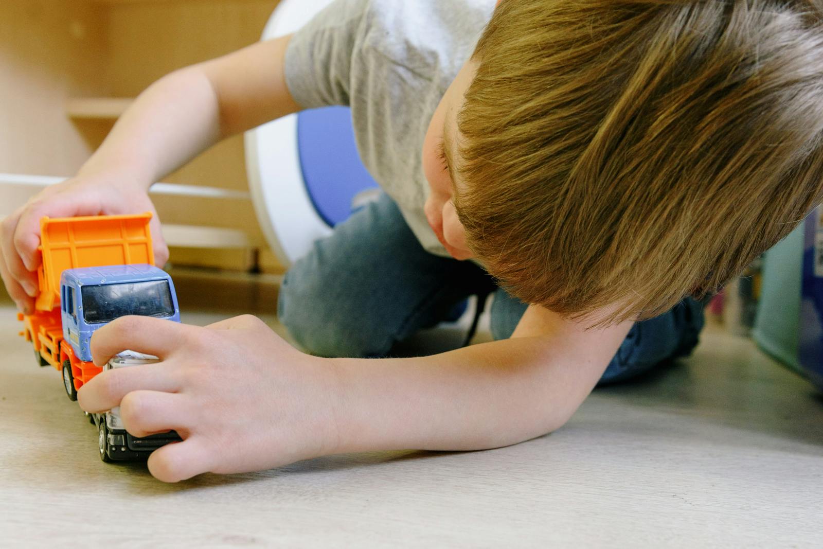 A young boy playing alone with toys.