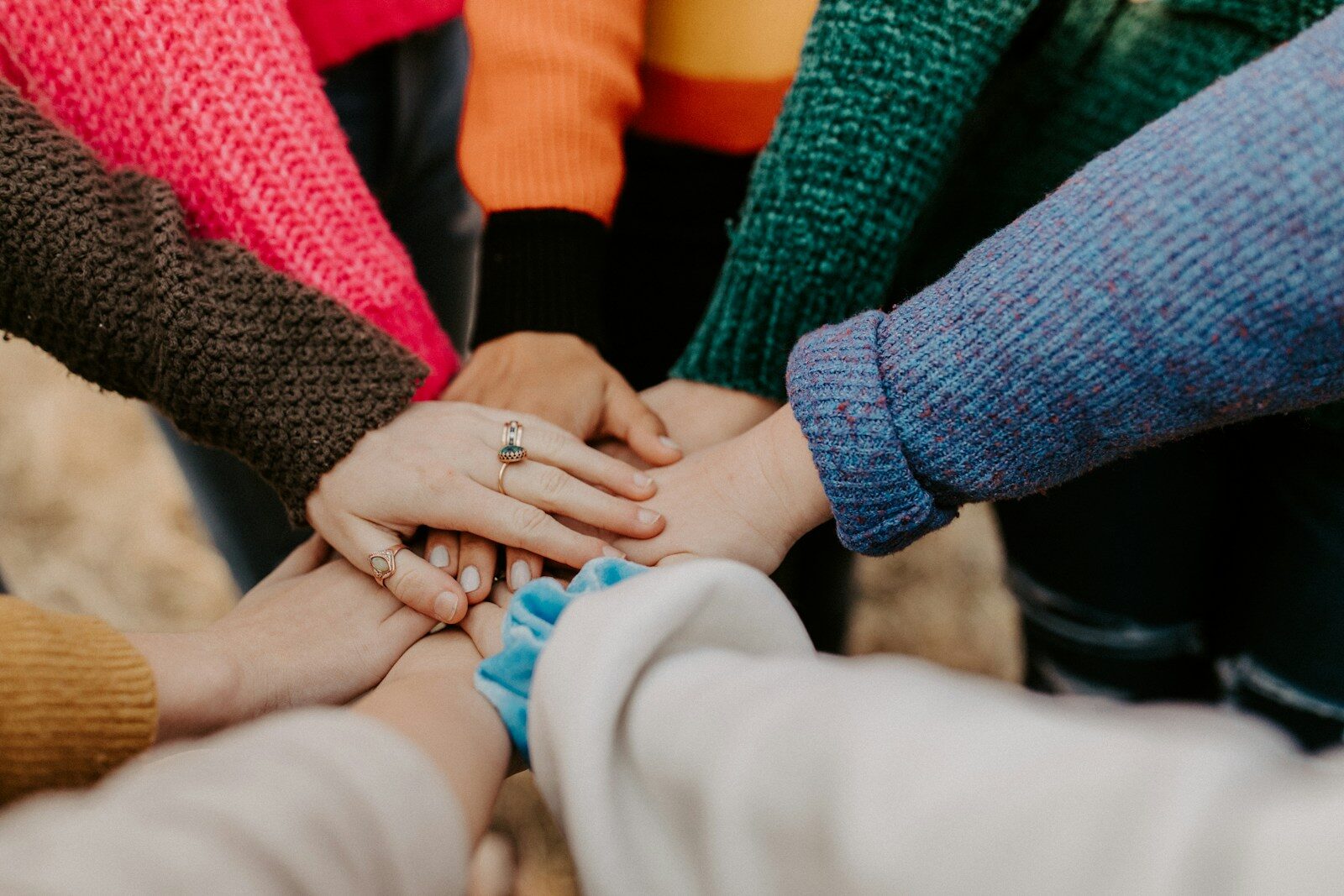 multiple hands in a circle representing teamwork
